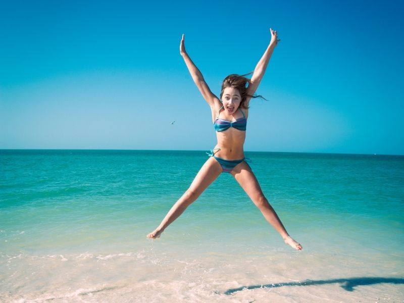 girl jumping for joy on marco island beach